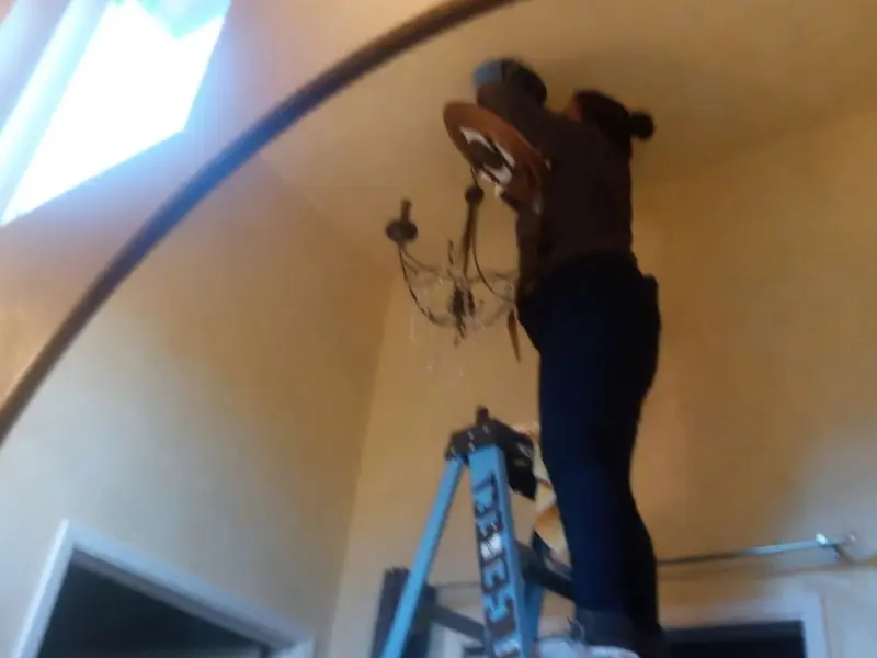 Electrician installing a chandelier in a Westmont residence